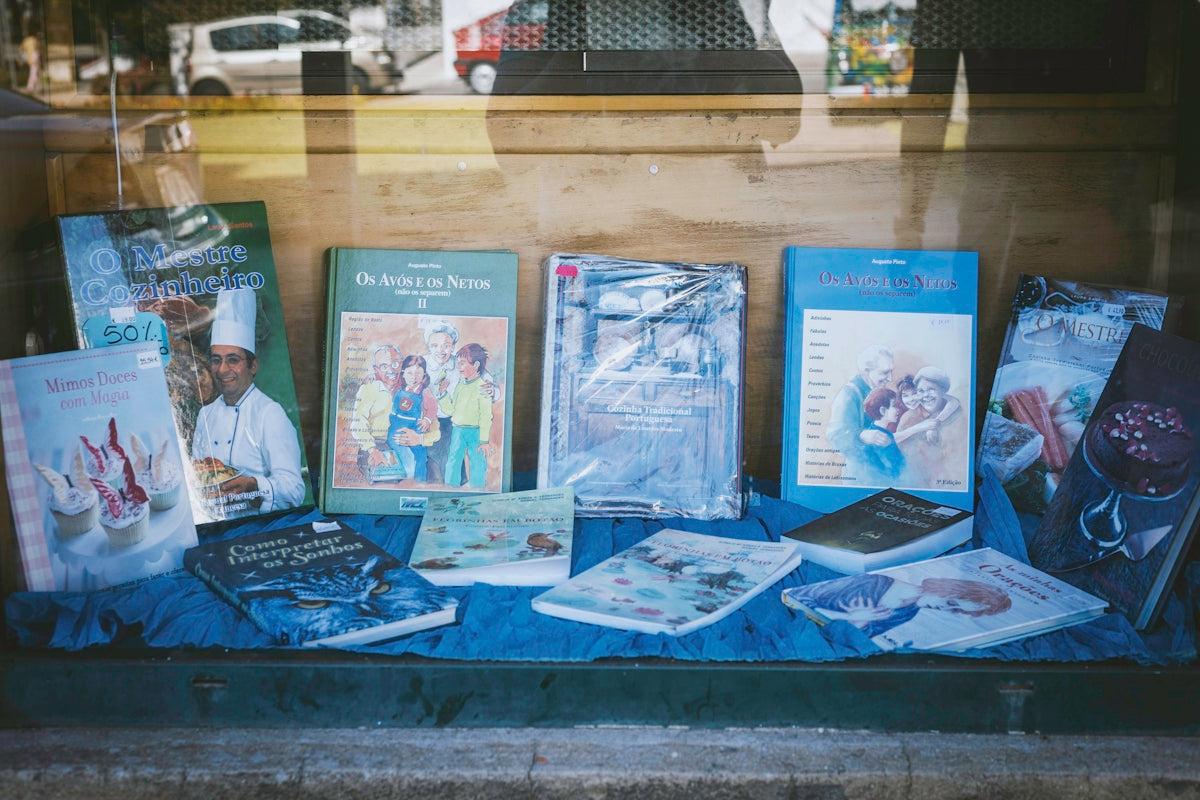 a bunch of books on a table in a window