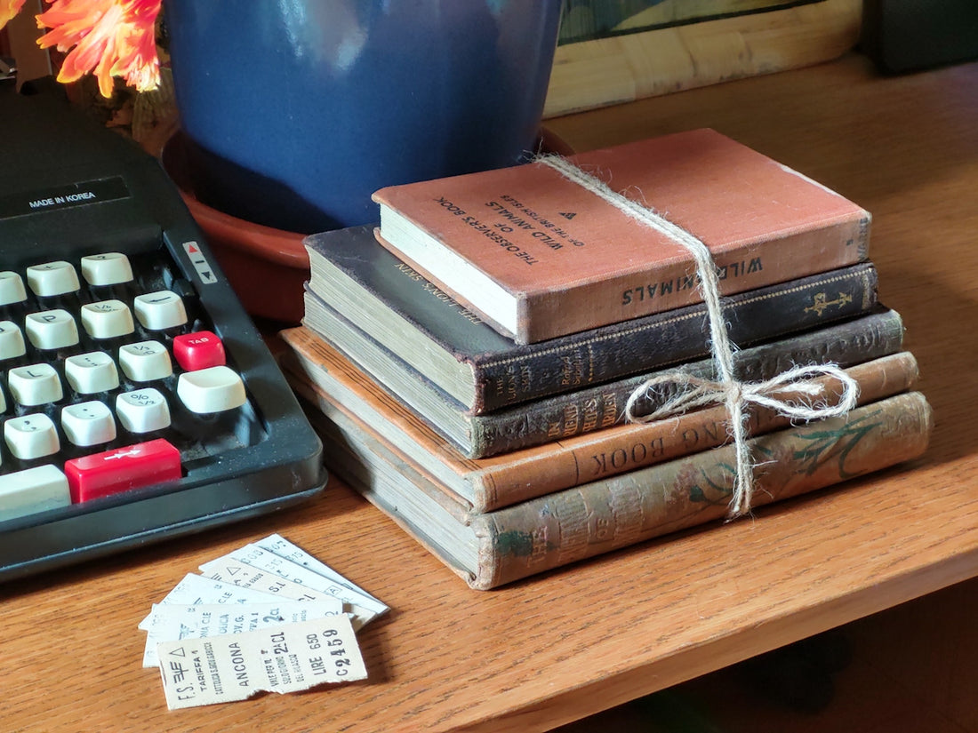 a stack of books sitting next to a typewriter