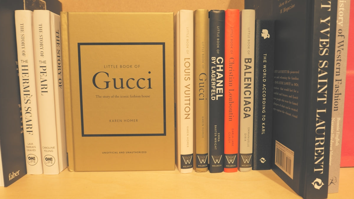 a row of books sitting on top of a wooden shelf