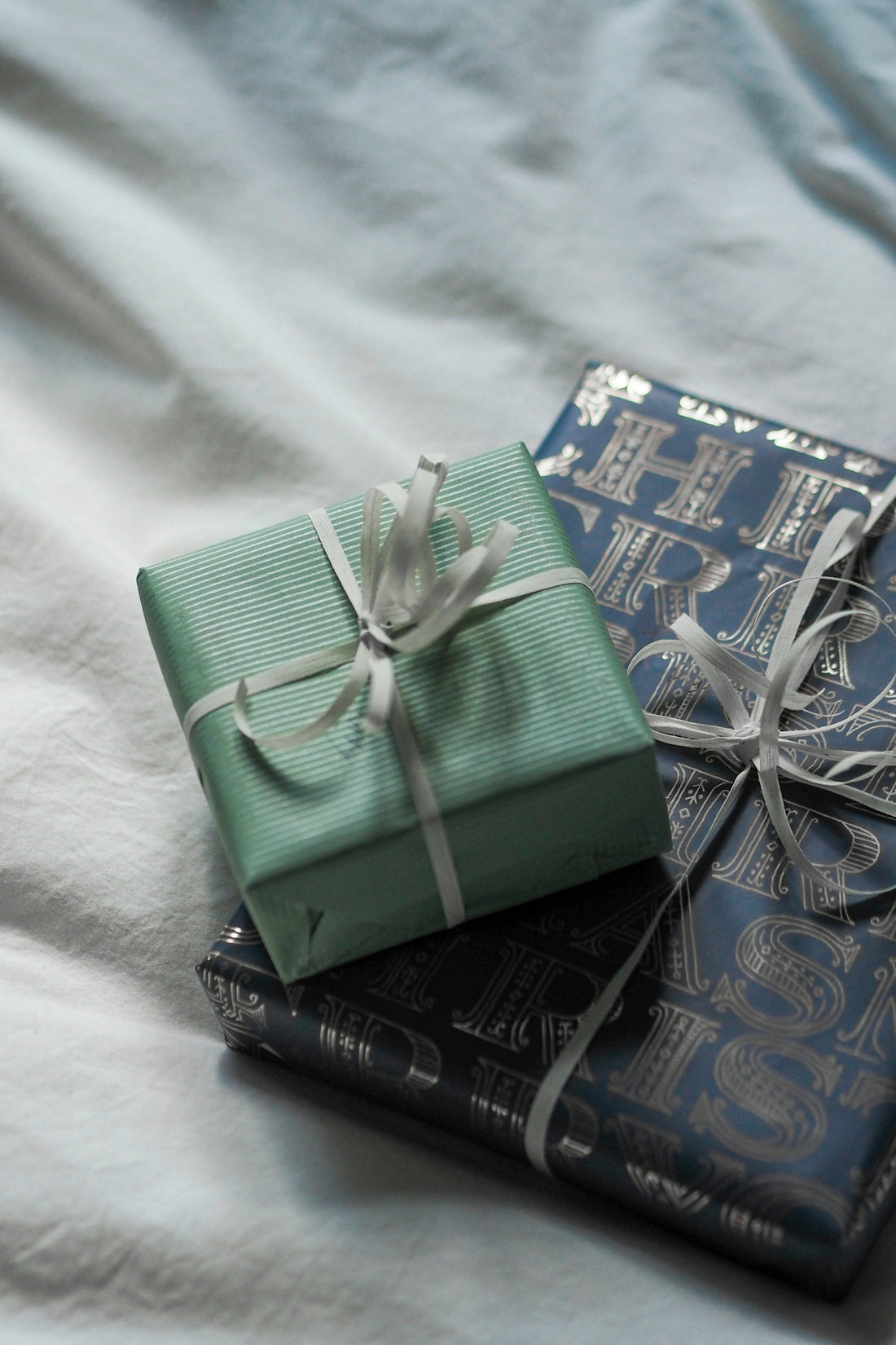 A couple of wrapped presents sitting on top of a bed