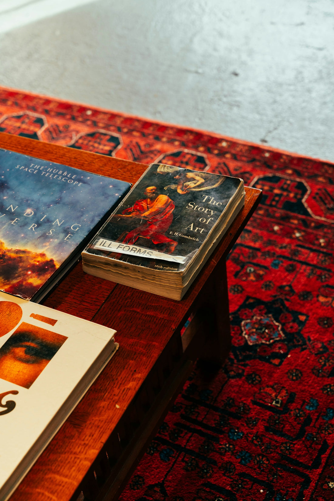 A table topped with books on top of a red rug