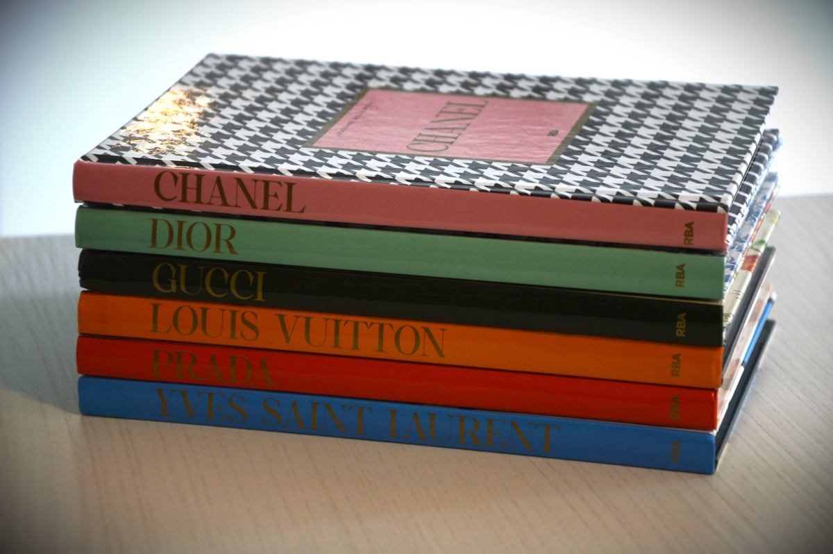 Stack of fashion books with designer names