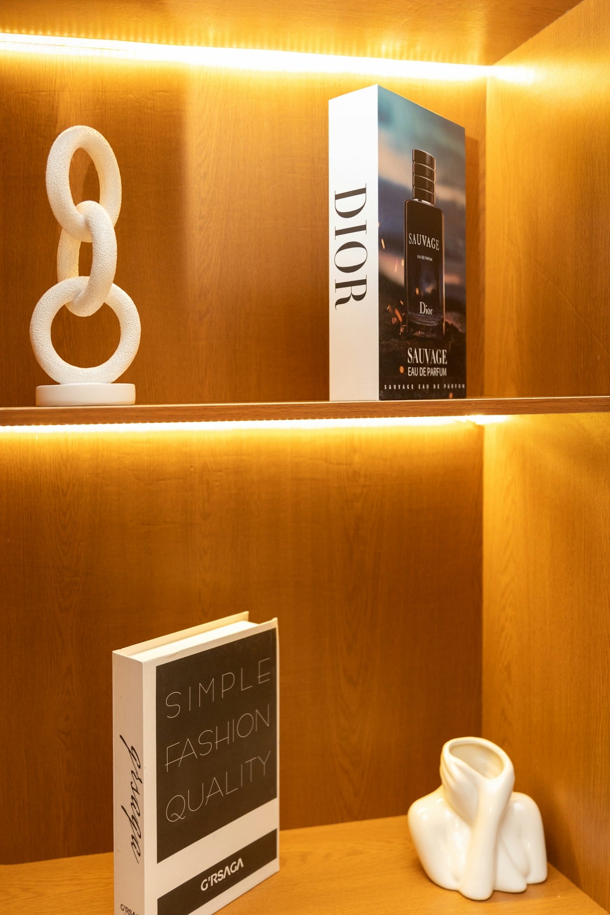 Stylish wooden shelves displaying decorative books and white sculptures.
